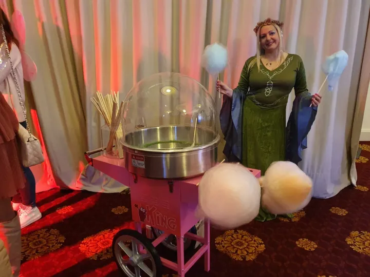 Algodones de azúcar blancos y azules junto al carrito en una fiesta temática