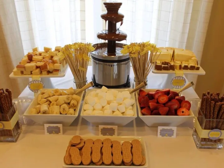 Fuente de chocolate con fruta, nubes y galletas para mojar