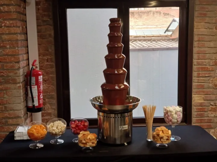 Fuente de chocolate de varios pisos con copas de toppings