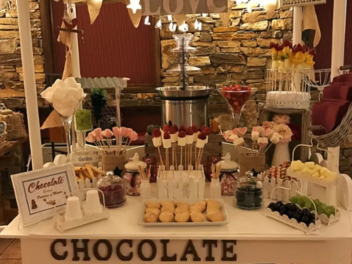 Fuente de chocolate para bodas en un carrito con las iniciales de los novios