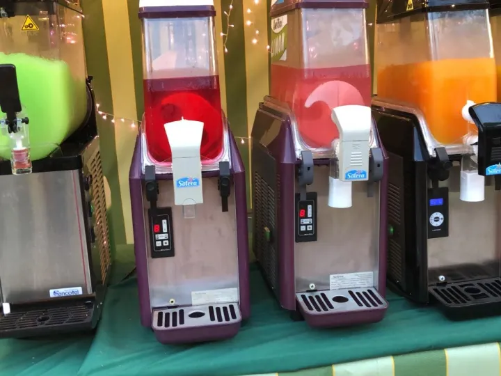 Máquinas de granizados de distintos sabores y colores en una feria