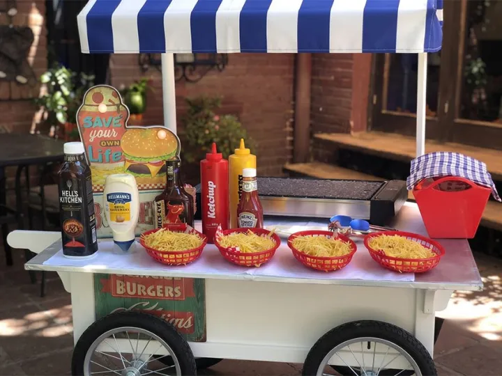 Detalle del carrito de hamburguesas con plancha, salsas y cestas