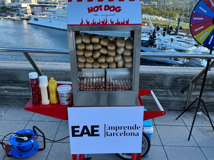 Carrito de hot dog con panel personalizado en una terraza junto al mar