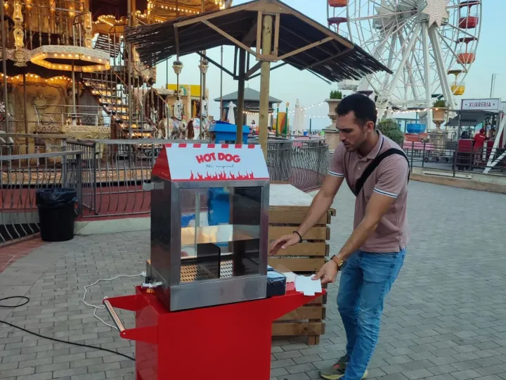 Carrito de perritos calientes en una fiesta con atracciones de feria