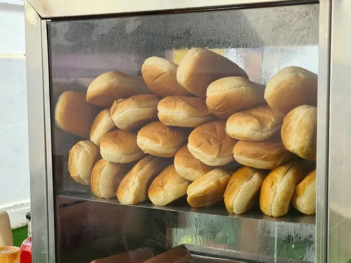 Vitrina de la máquina de hot dogs con panecillos arriba y salchichas abajo