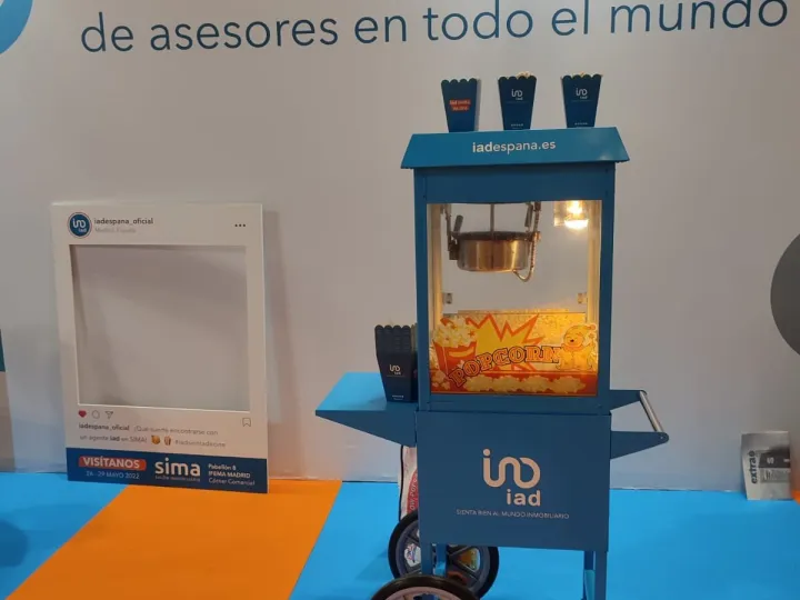 Carrito de palomitas azul vinilado con los colores de la marca en una feria