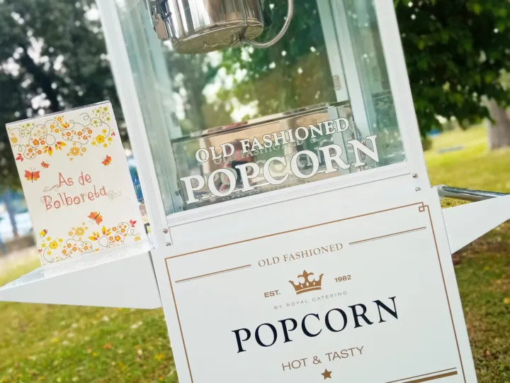 Detalle del carrito de palomitas con cartel de palomitas recién hechas en un jardín