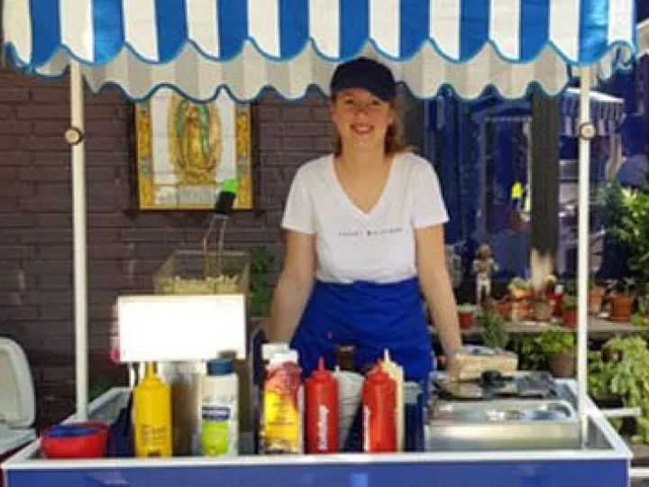 Server at the fries cart with fryer and sauces