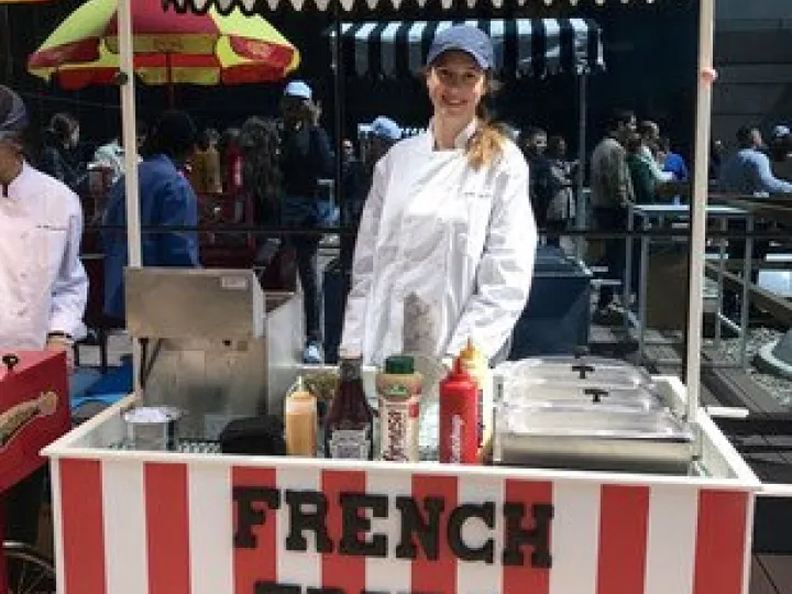 Red and white striped fries cart at an outdoor event