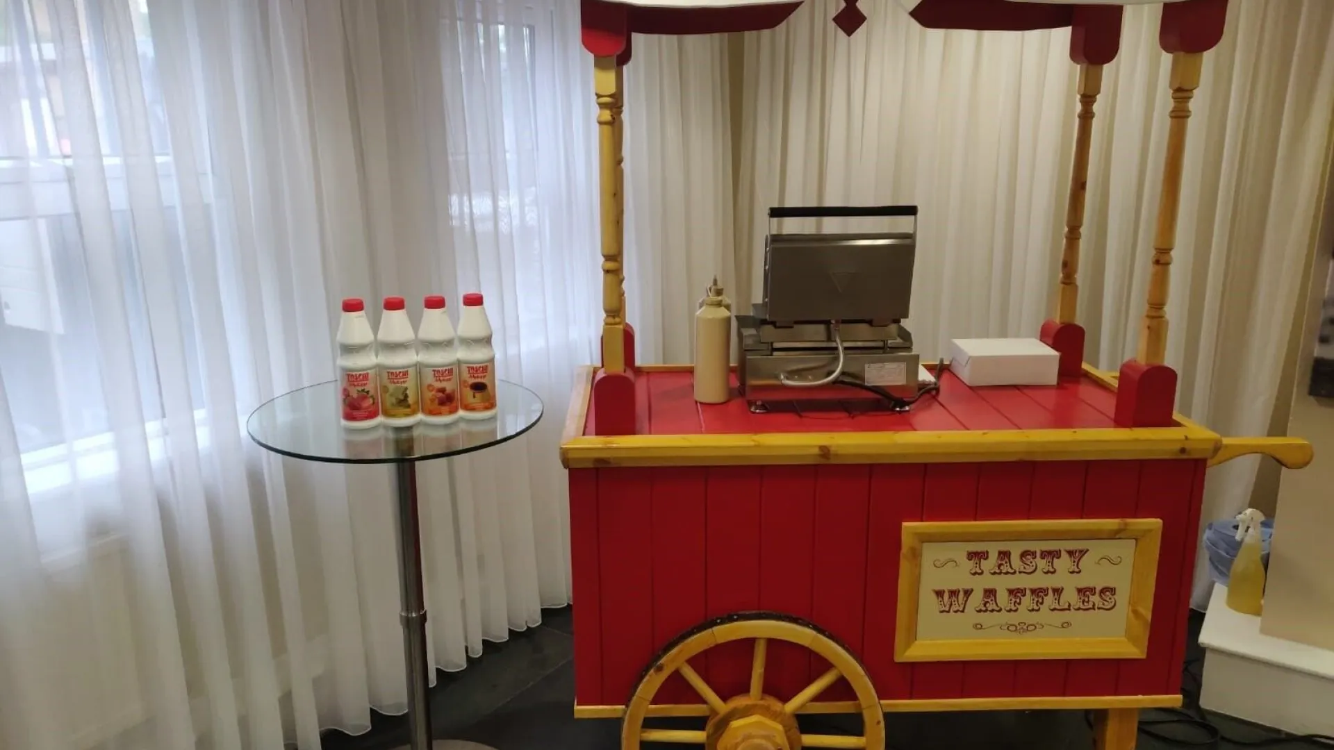 Carrito de gofres de madera roja con rueda de carreta y gofrera profesional