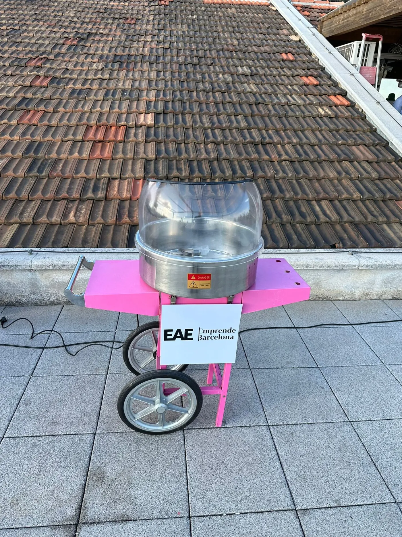 Carrito de algodón de azúcar con panel frontal personalizado en una terraza