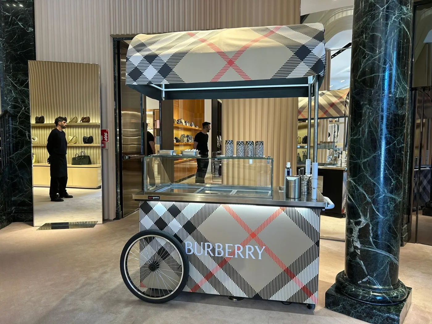 Carrito de helados vinilado entero con el estampado de una marca de moda en una tienda