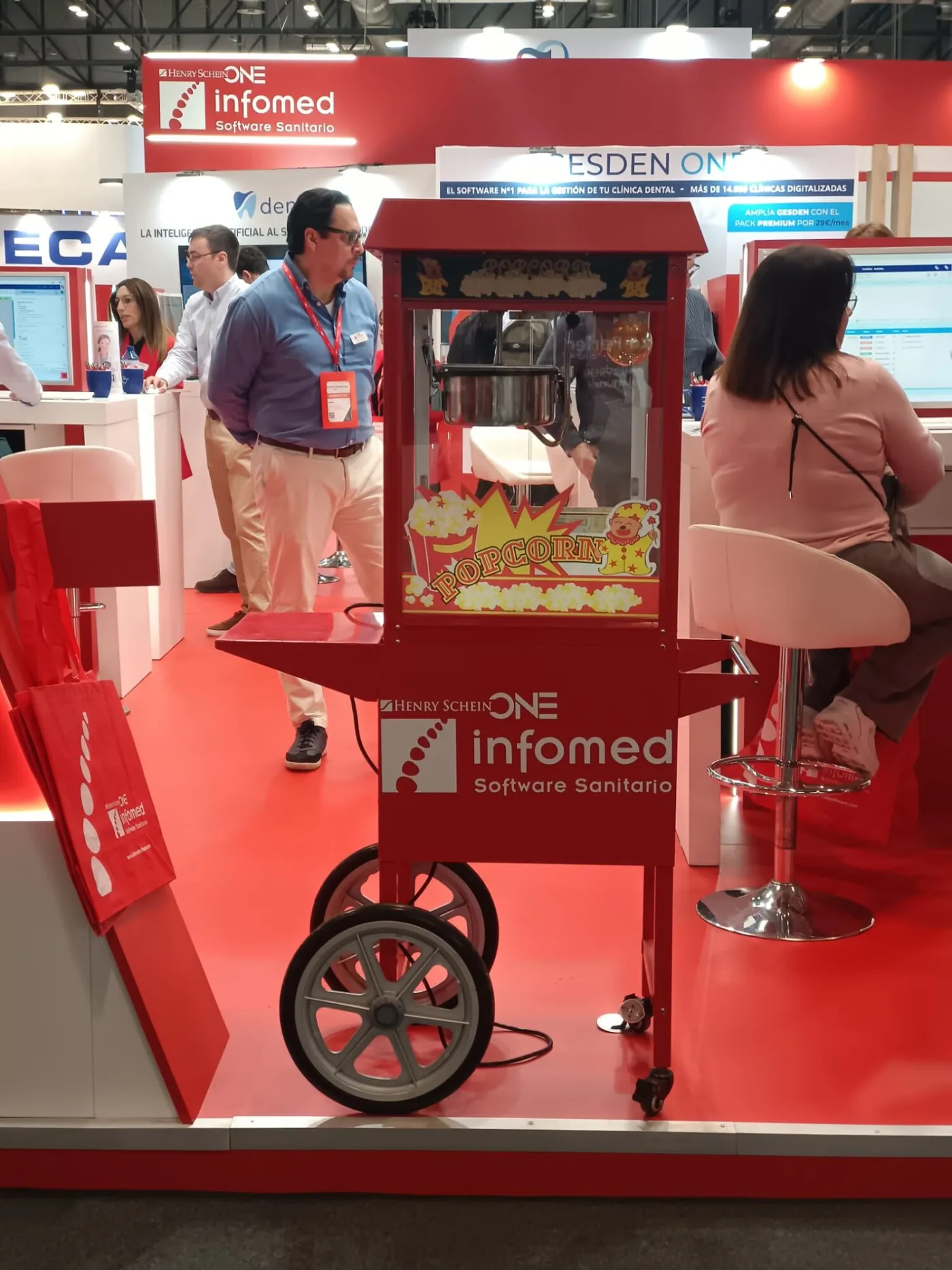 Carrito de palomitas con logotipo de empresa en un stand de feria